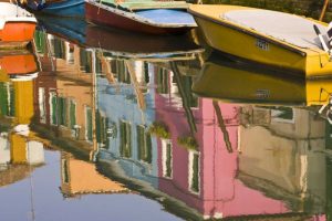 Italy, Burano Boats on a canal with reflections